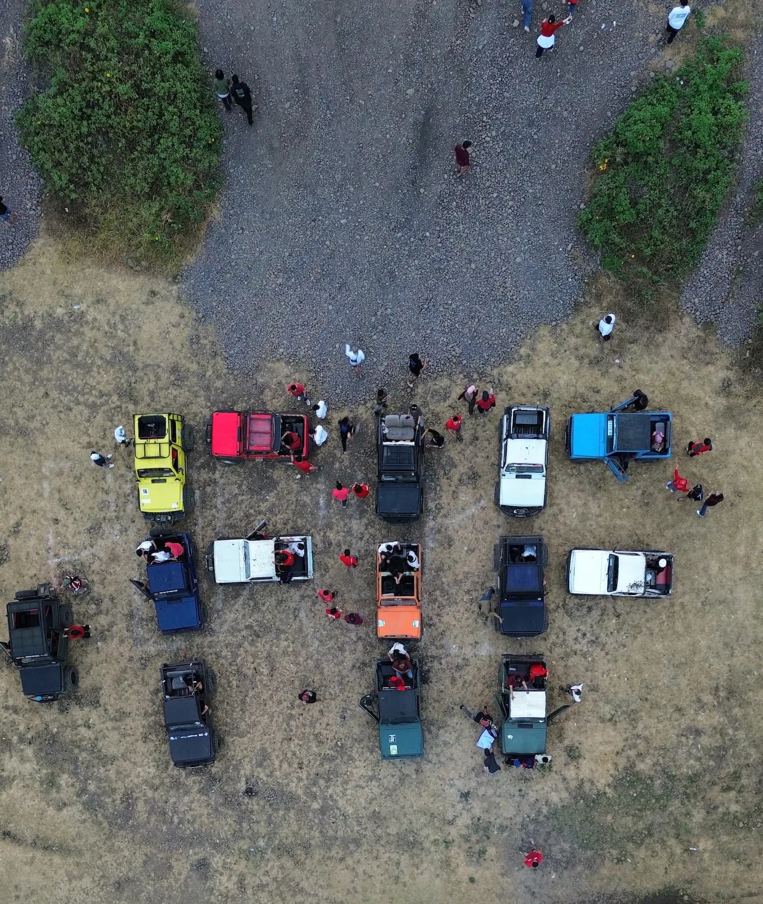 Foto udara belasan Jeep terparkir berjajar di lapangan dengan rombongan peserta berkaus merah di sekitarnya